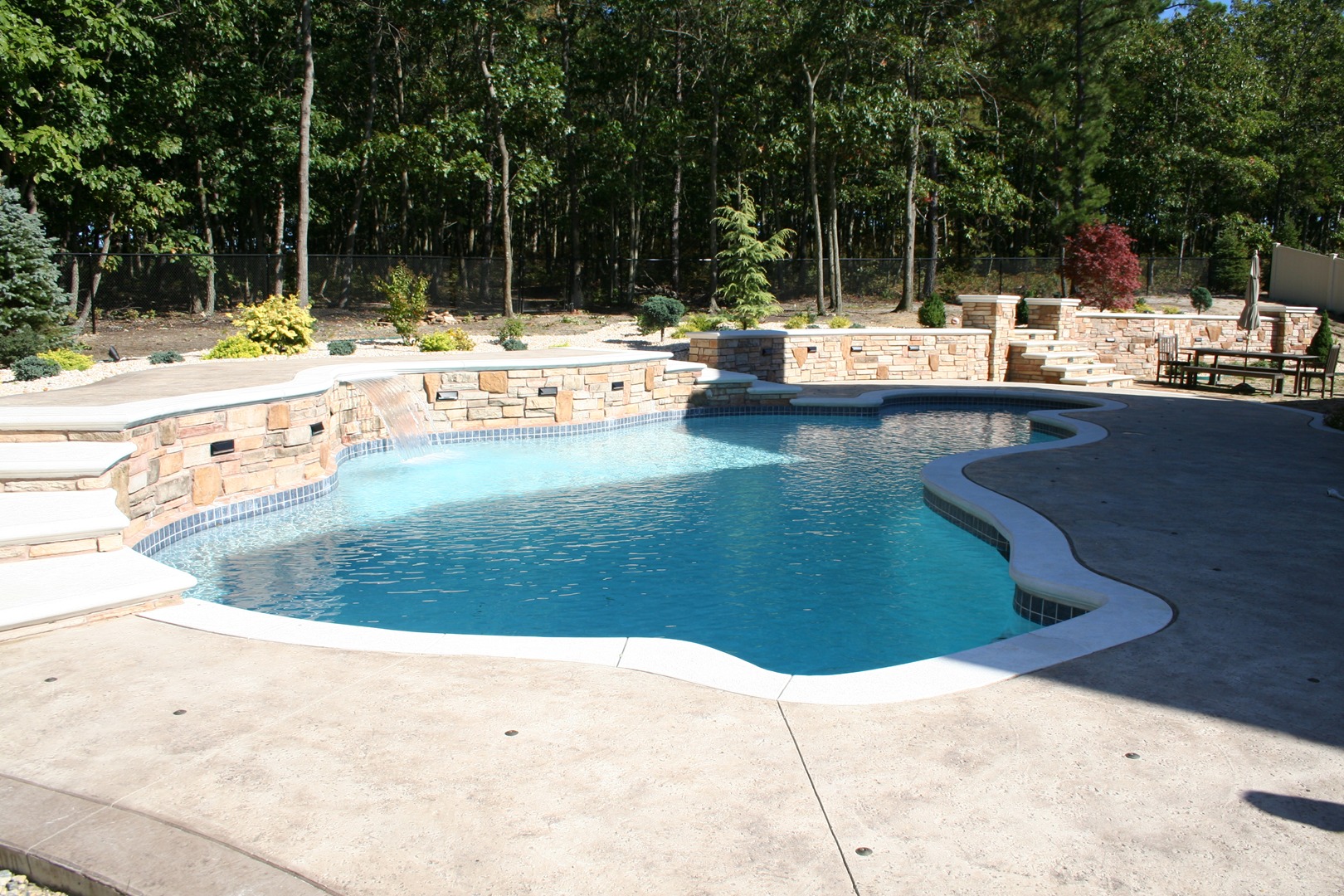 stamped concrete pool patio with retaining wall