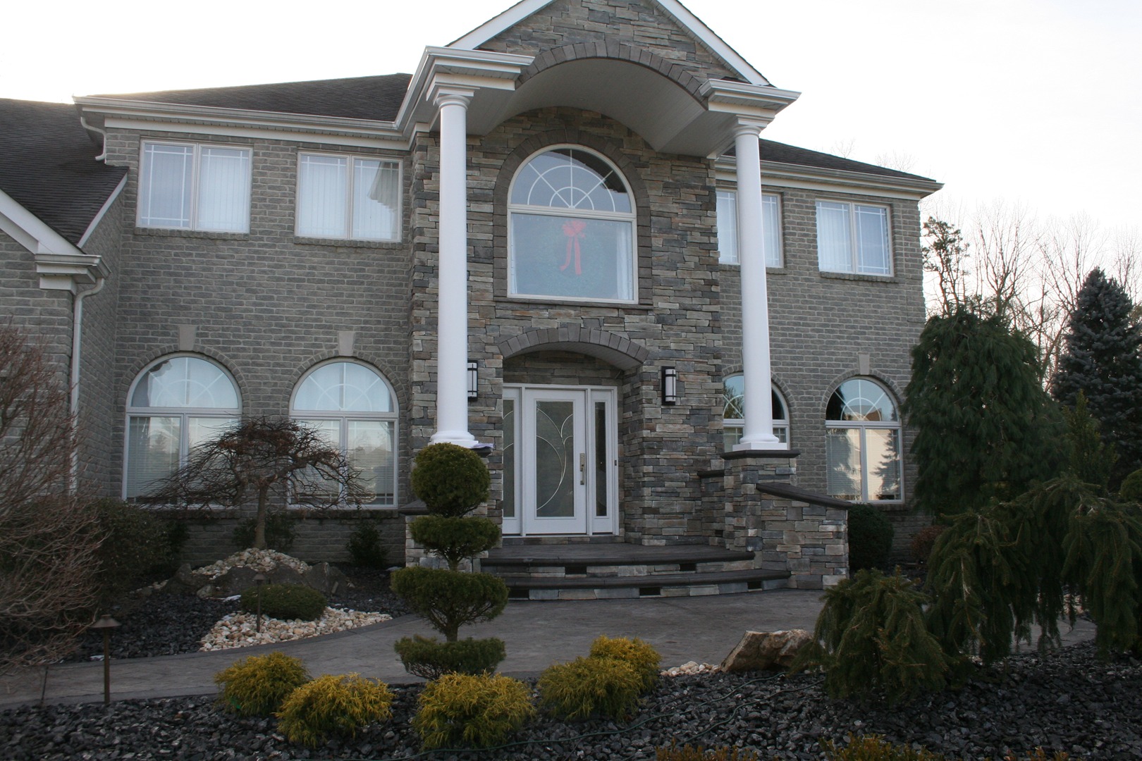 cultured stone entrance with stamped concrete walkway