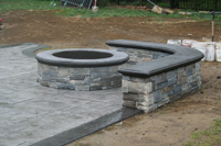stamped concrete patio and custom fire pit and seating wall